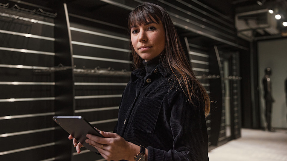 Designer posing for the camera holding a tablet