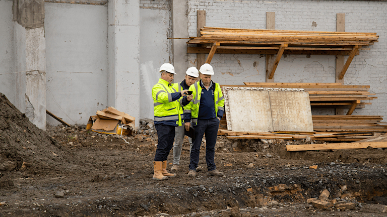 Contractors using Procore on a phone