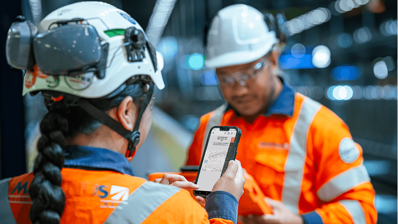 A woman contractor using Procore on a phone